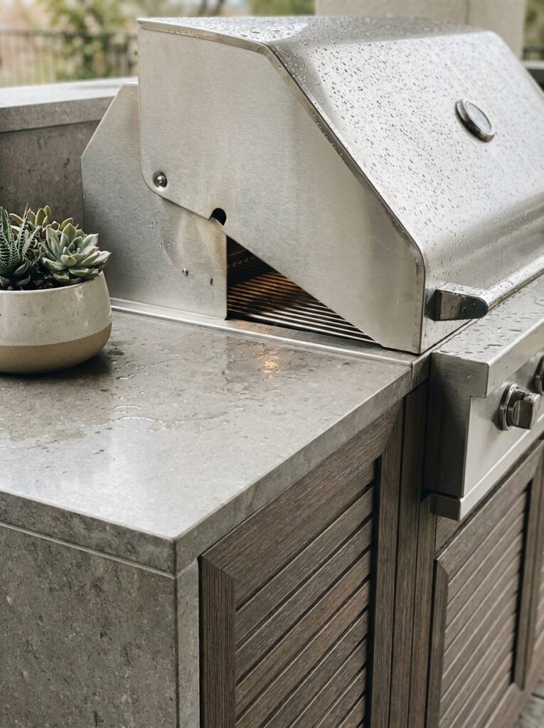 Weather resistant outdoor kitchen materials including stainless steel grill and stone countertop