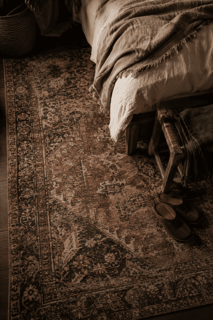 Dark boho bedroom rug styling with vintage textured rug and earthy layered decor inspiration
